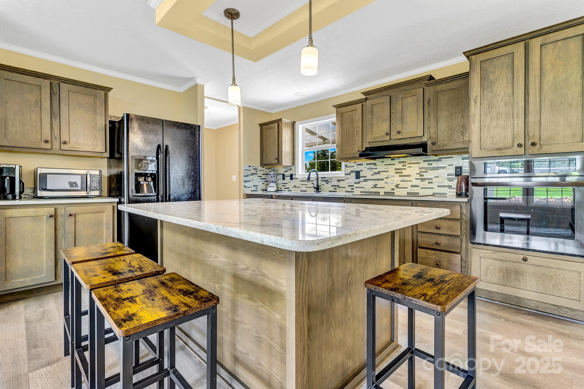 185 Bradshaw Circle Candler, NC 28715 - Photo 10 of 38 a kitchen with stainless steel appliances kitchen island granite countertop a table chairs in it and wooden floors