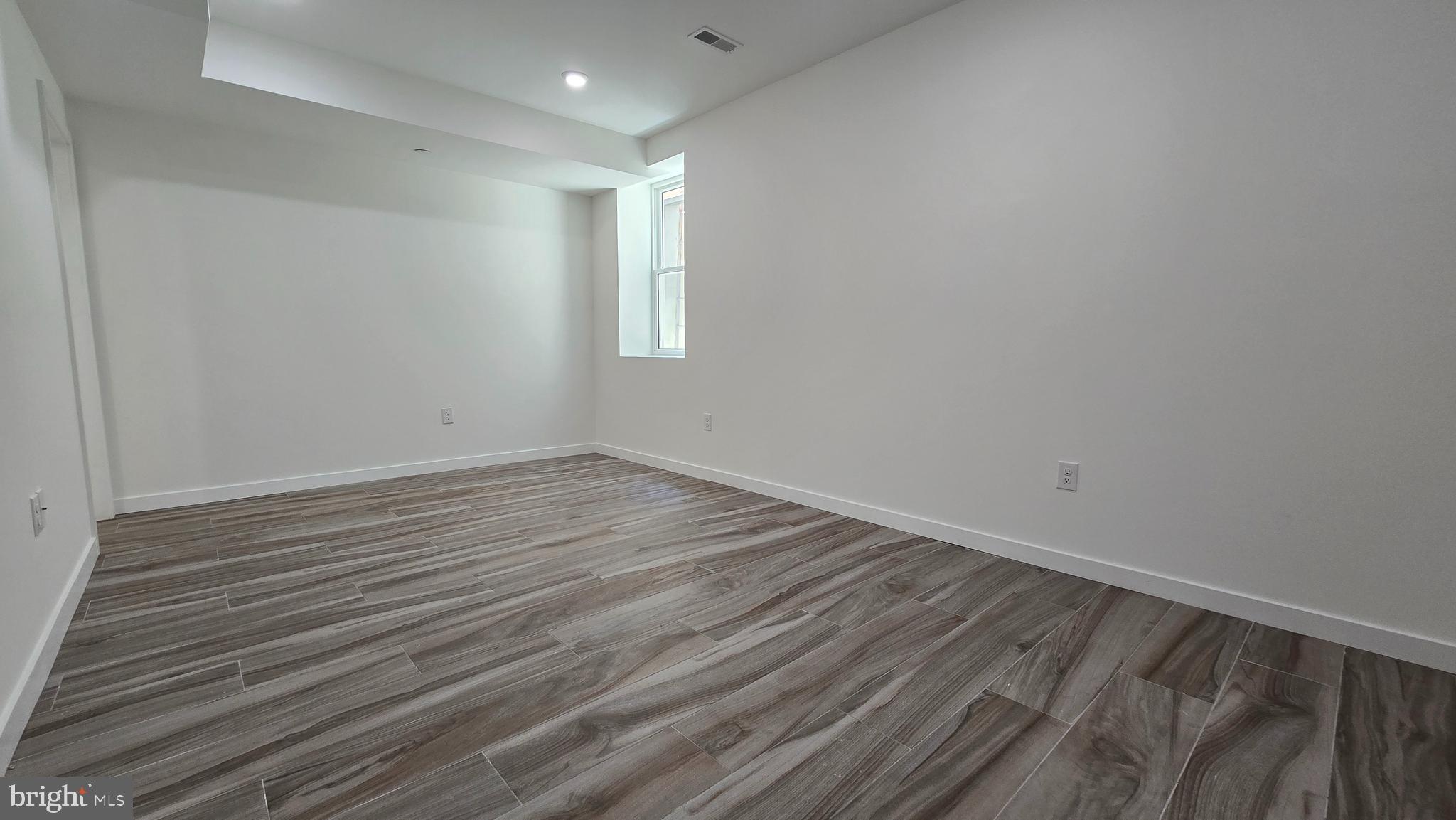 300 Budd Street, Unit C1 Philadelphia, PA 19104 - Photo 12 of 20 a view of an empty room with wooden floor and a window