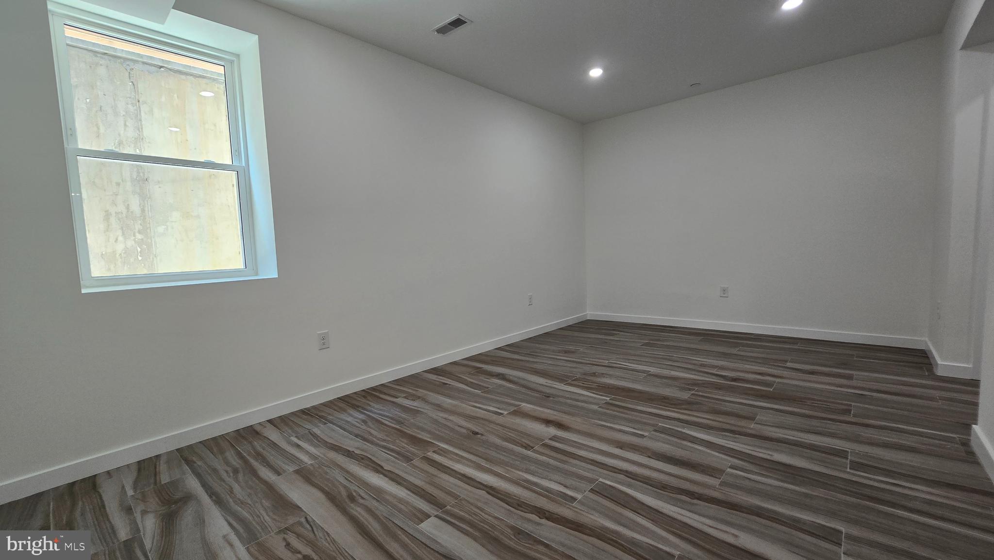 300 Budd Street, Unit C1 Philadelphia, PA 19104 - Photo 14 of 20 an empty room with wooden floor and windows