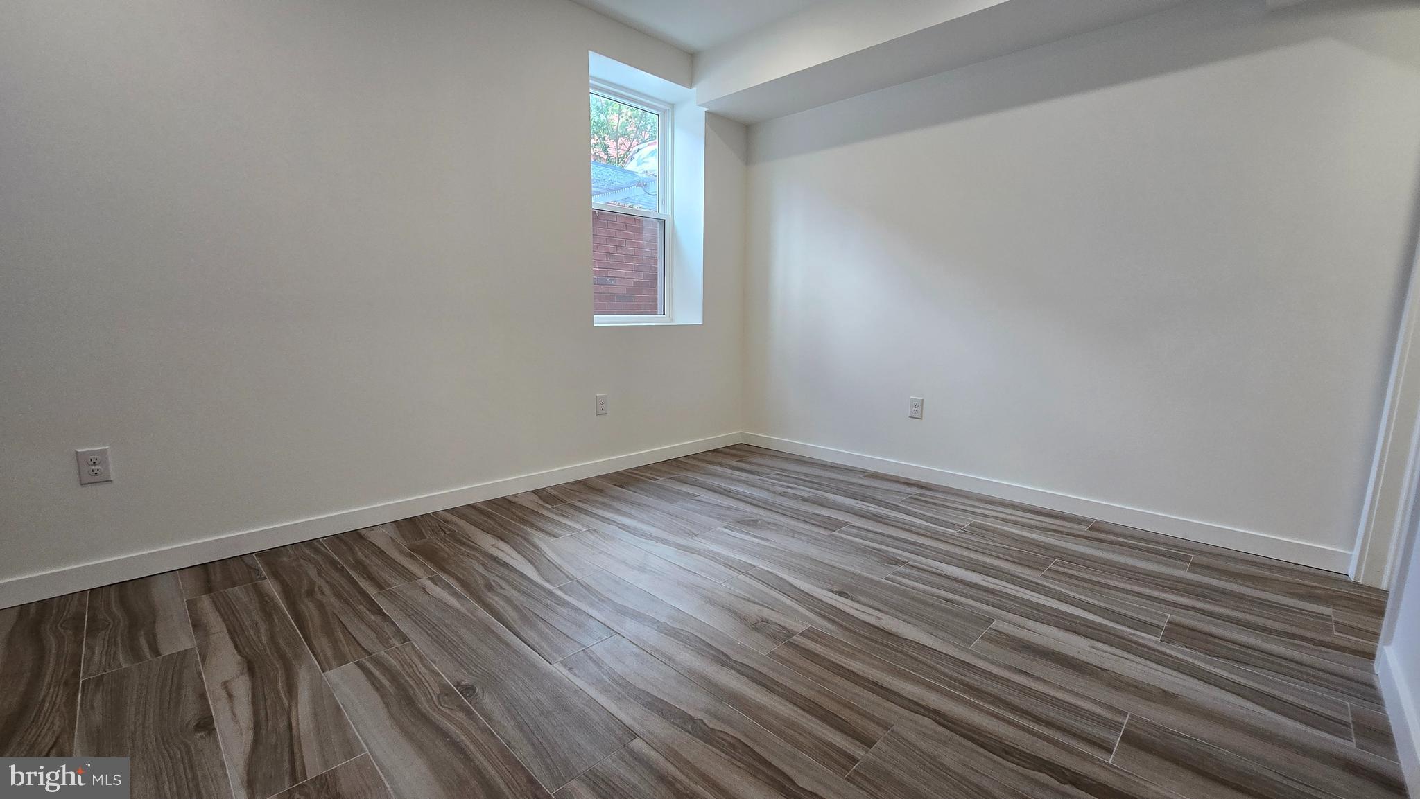 300 Budd Street, Unit C1 Philadelphia, PA 19104 - Photo 17 of 20 a view of an empty room with wooden floor and a window