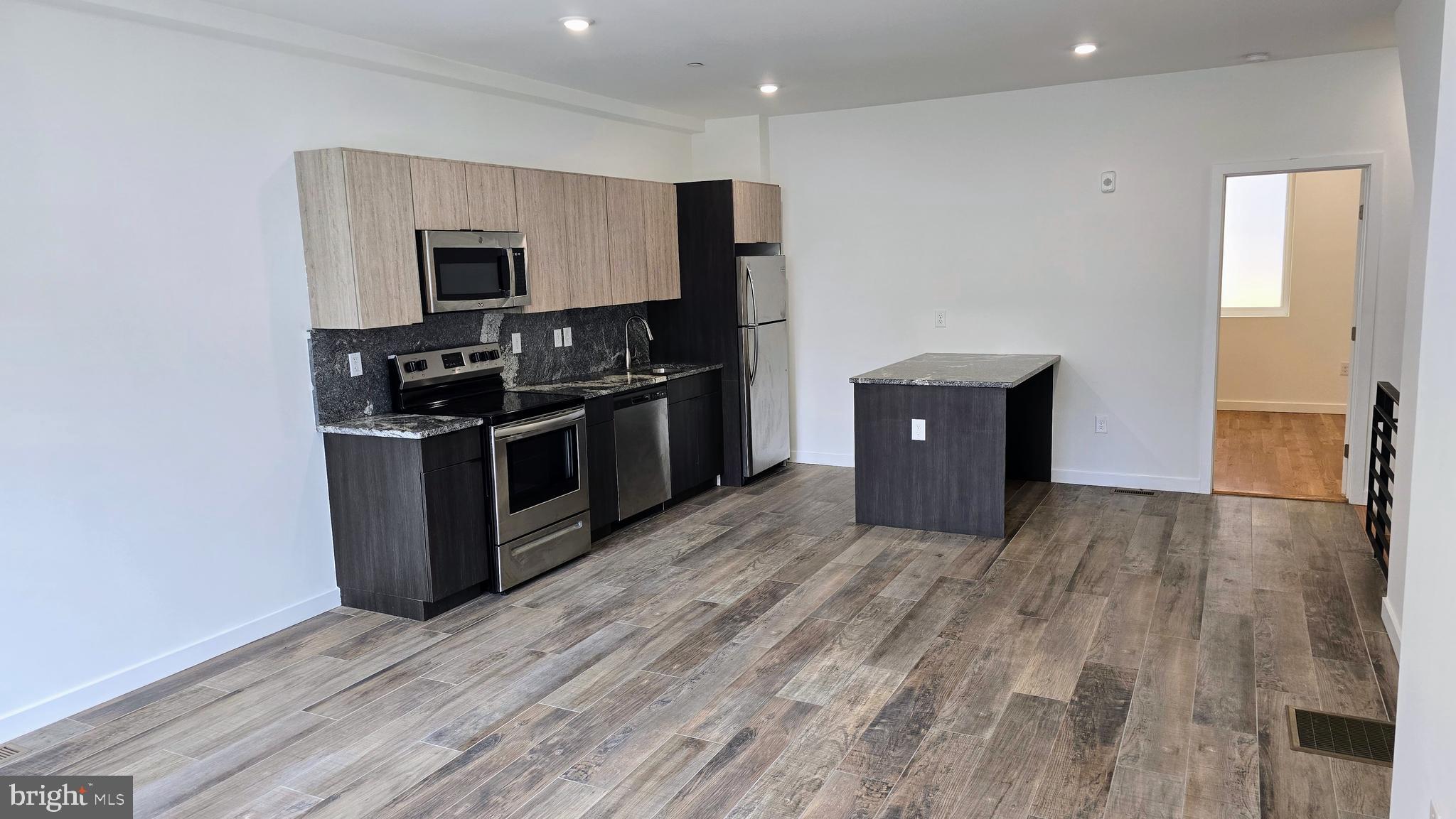300 Budd Street, Unit C1 Philadelphia, PA 19104 - Photo 6 of 20 a kitchen with stainless steel appliances granite countertop a stove and a refrigerator