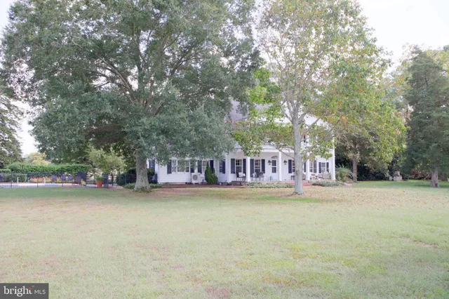 a spacious bedroom with a bed a fireplace and a flat tv screen on dresser