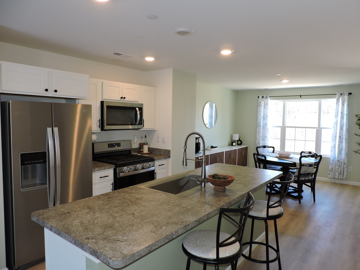 3726 Bailey Road Yorkville, IL 60560 - Photo 4 of 21 a kitchen with granite countertop a table chairs microwave and refrigerator