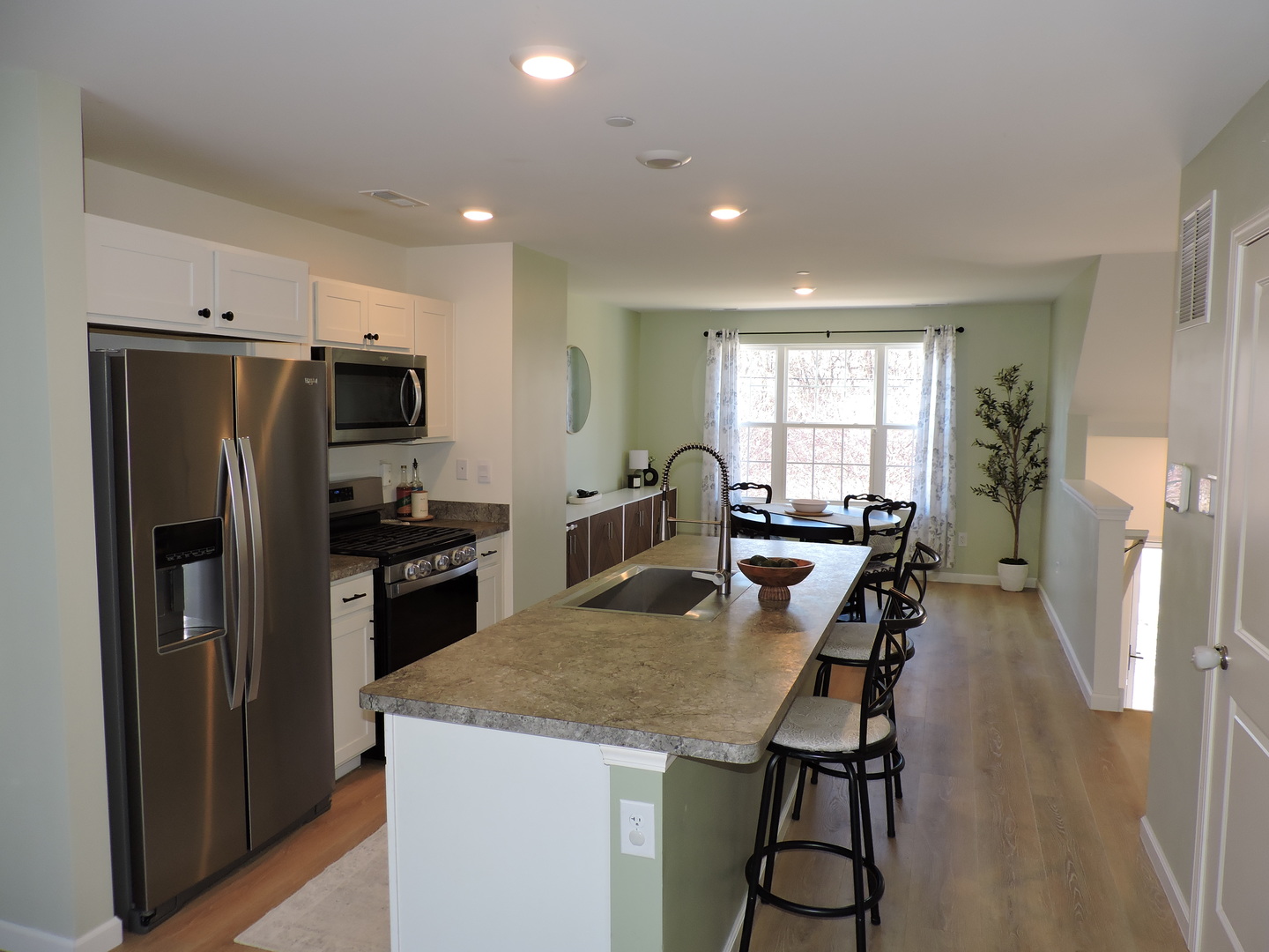 3726 Bailey Road Yorkville, IL 60560 - Photo 5 of 21 a kitchen with a refrigerator a stove a sink dishwasher a dining table and chairs with wooden floor