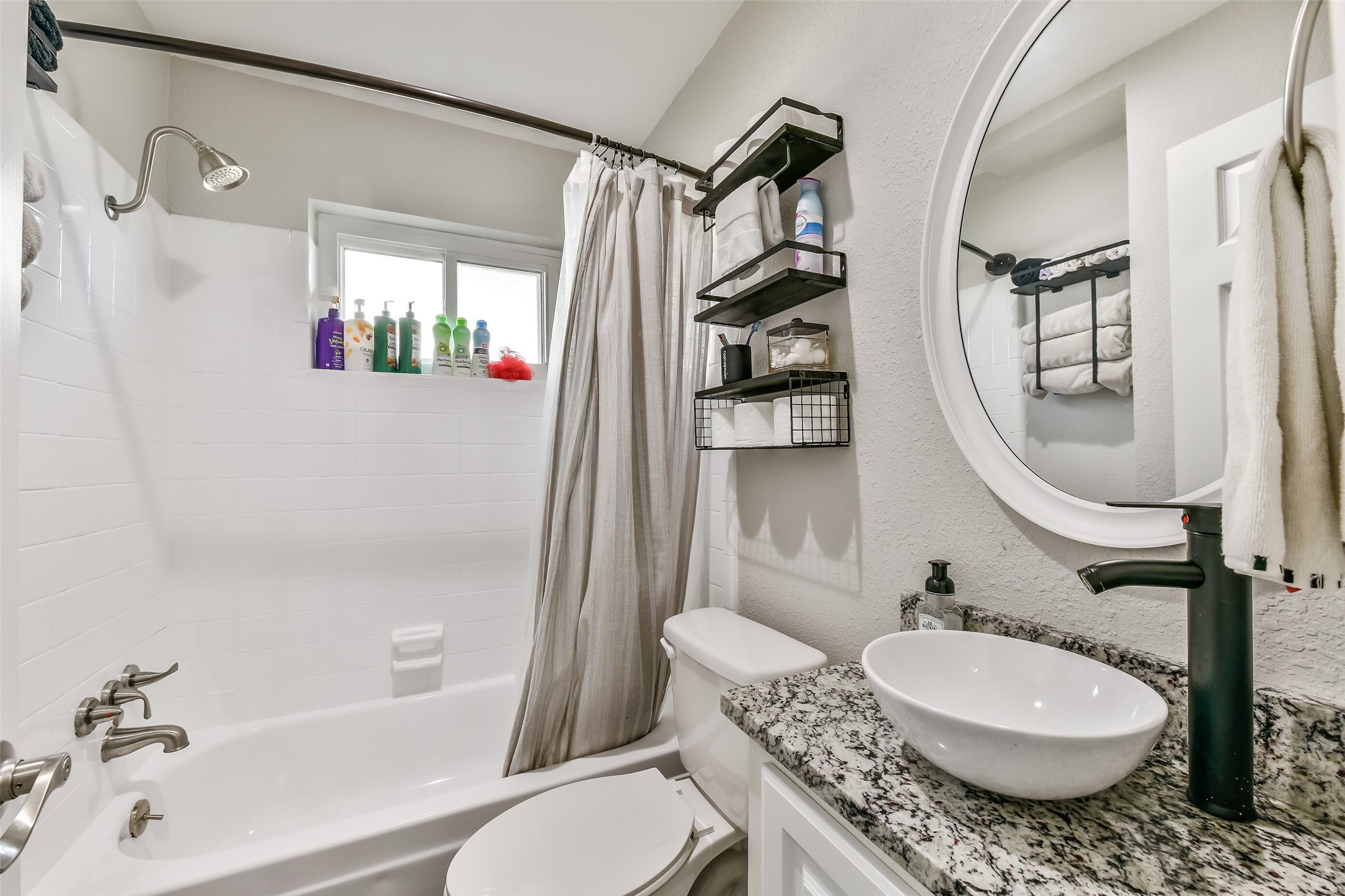 5421 Bramble Lane Dickinson, TX 77539 - Photo 22 of 26 a bathroom with a granite countertop toilet a sink and a mirror