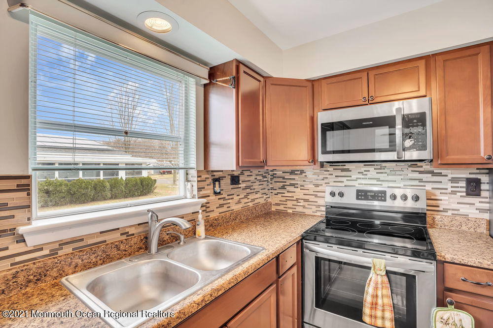 54 Markham Road Brick, NJ 08724 - Photo 19 of 35 a kitchen with granite countertop a sink stove top oven and cabinetry