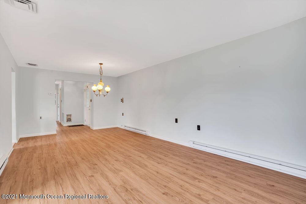 54 Markham Road Brick, NJ 08724 - Photo 8 of 35 a view of an empty room with wooden floor and chandelier
