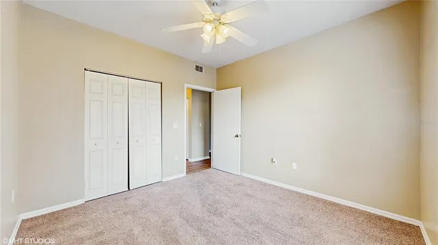 an empty room with a ceiling fan and a window