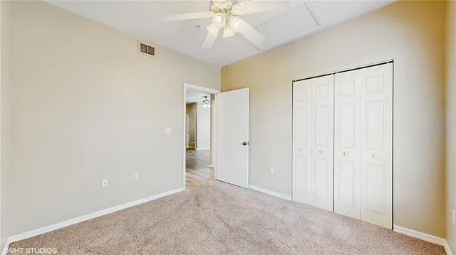 a view of an empty room and chandelier fan