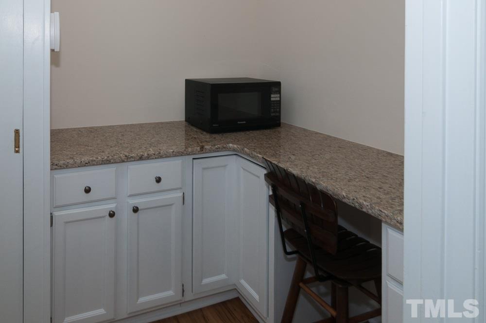 1445 Princess Anne Road Raleigh, NC 27607 - Photo 22 of 25 a kitchen with a granite countertop cabinets and a stove top oven