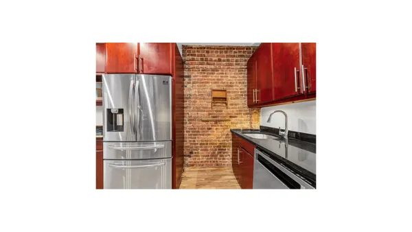 a kitchen with stainless steel appliances granite countertop a refrigerator and a stove