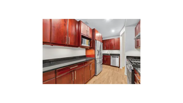 a kitchen with stainless steel appliances granite countertop a refrigerator and a stove top oven