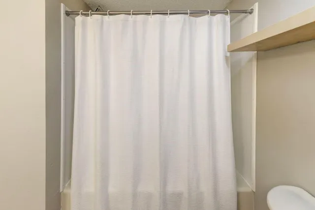 a bathroom with a shower curtain and curtain