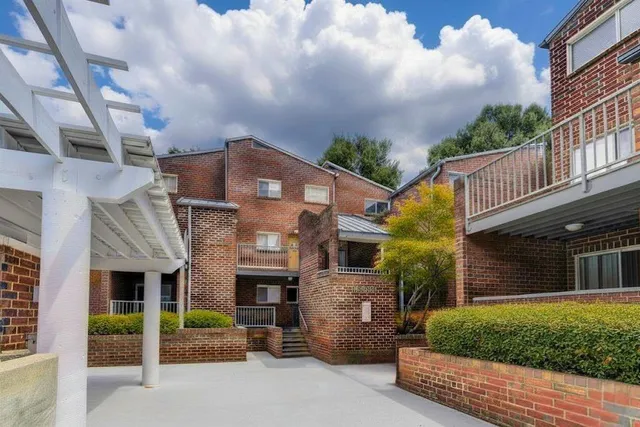 a view of a swimming pool with a yard and lawn chairs with wooden fence