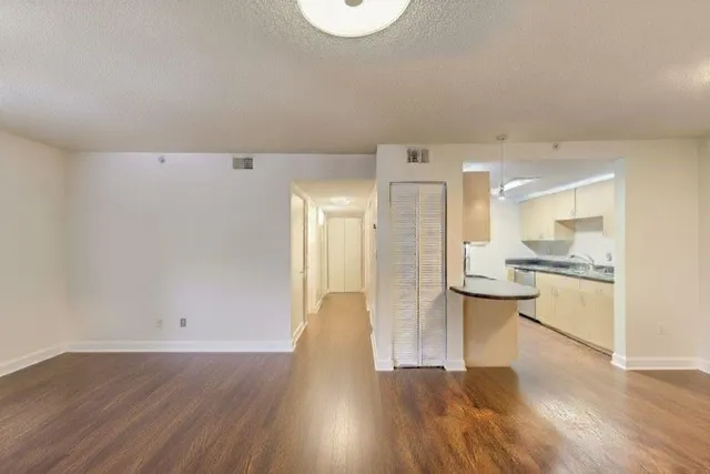a view of kitchen with refrigerator and wooden floor