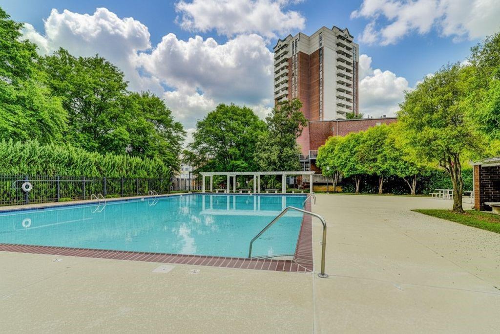 381 Ralph McGill Boulevard Northeast, Unit E Atlanta, GA 30312 - Photo 23 of 27 a view of a swimming pool with a yard and lawn chairs with wooden fence