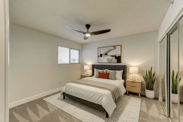 a bedroom with a bed and a potted plant