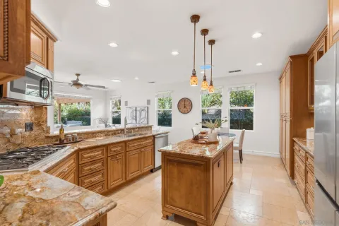 a dining hall with stainless steel appliances granite countertop a stove and a sink