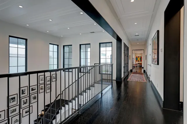 a view of a hallway with wooden floor and windows