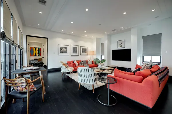 a living room with furniture a flat screen tv and kitchen view