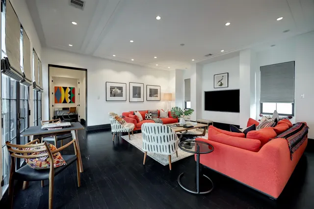 a living room with furniture a flat screen tv and kitchen view