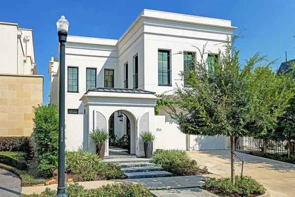 a view of a house with potted plants and large tree