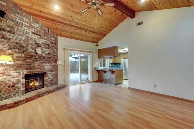 a view of empty room with wooden floor and fireplace