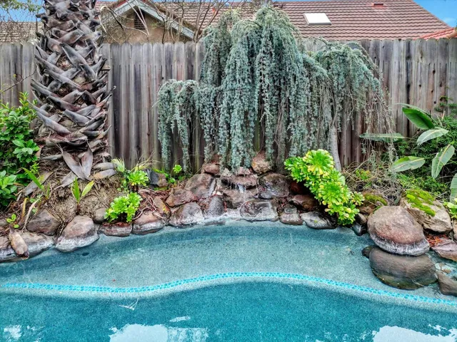 a view of a backyard with plants and chair fire pit