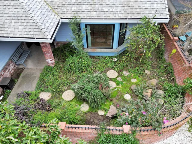 an aerial view of a house with a yard and potted plants
