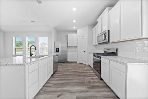 2004 Hardwick Drive Anna, TX 75409 - Photo 3 of 18 a large white kitchen with kitchen island a sink a stove and a refrigerator