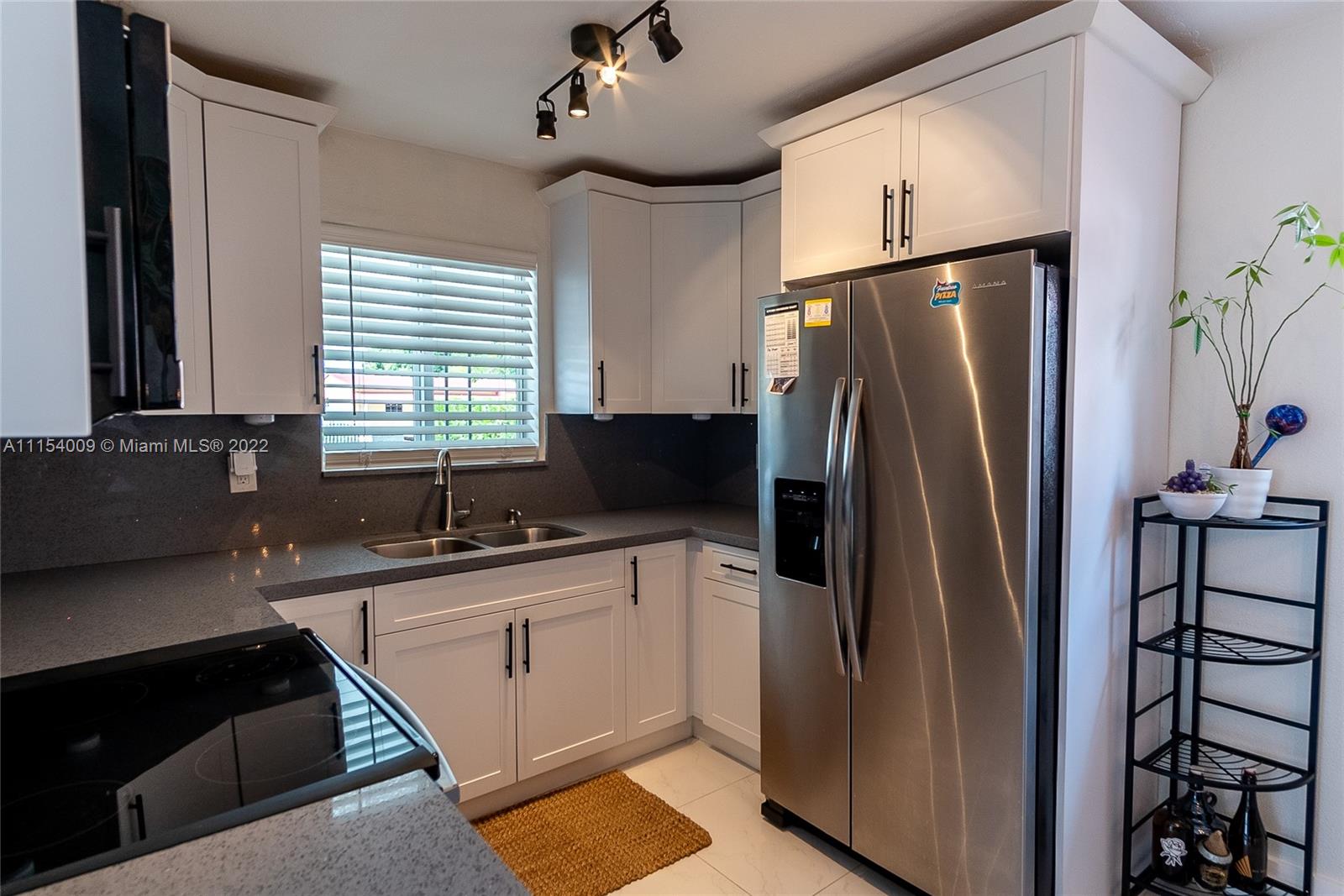 4235 East 9th Lane Hialeah, FL 33013 - Photo 14 of 34 a kitchen with stainless steel appliances granite countertop a refrigerator a sink a stove and a refrigerator