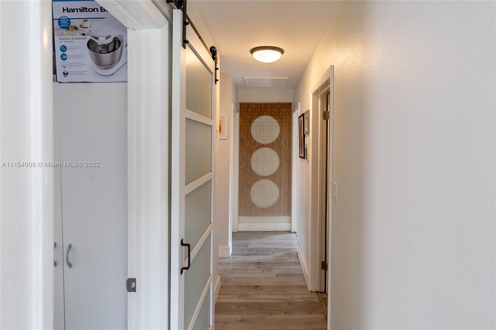 4235 East 9th Lane Hialeah, FL 33013 - Photo 18 of 34 a bathroom with a glass shower door and a door
