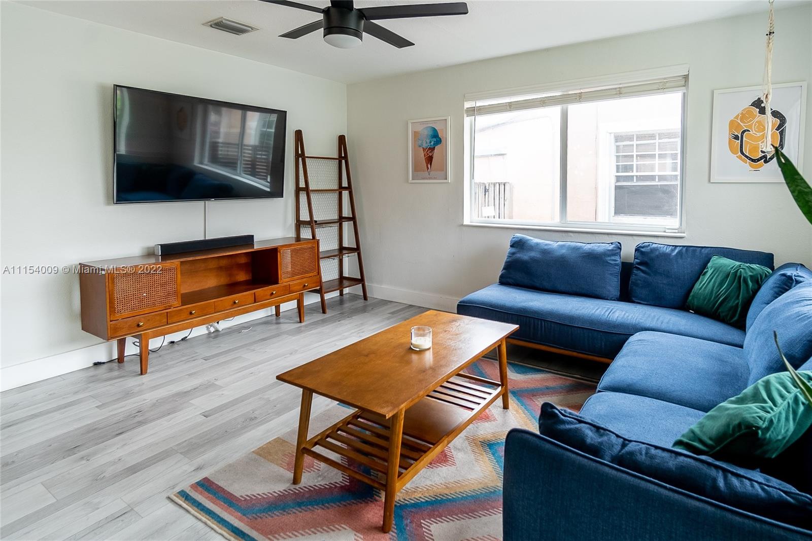 4235 East 9th Lane Hialeah, FL 33013 - Photo 4 of 34 a living room with furniture and a flat screen tv