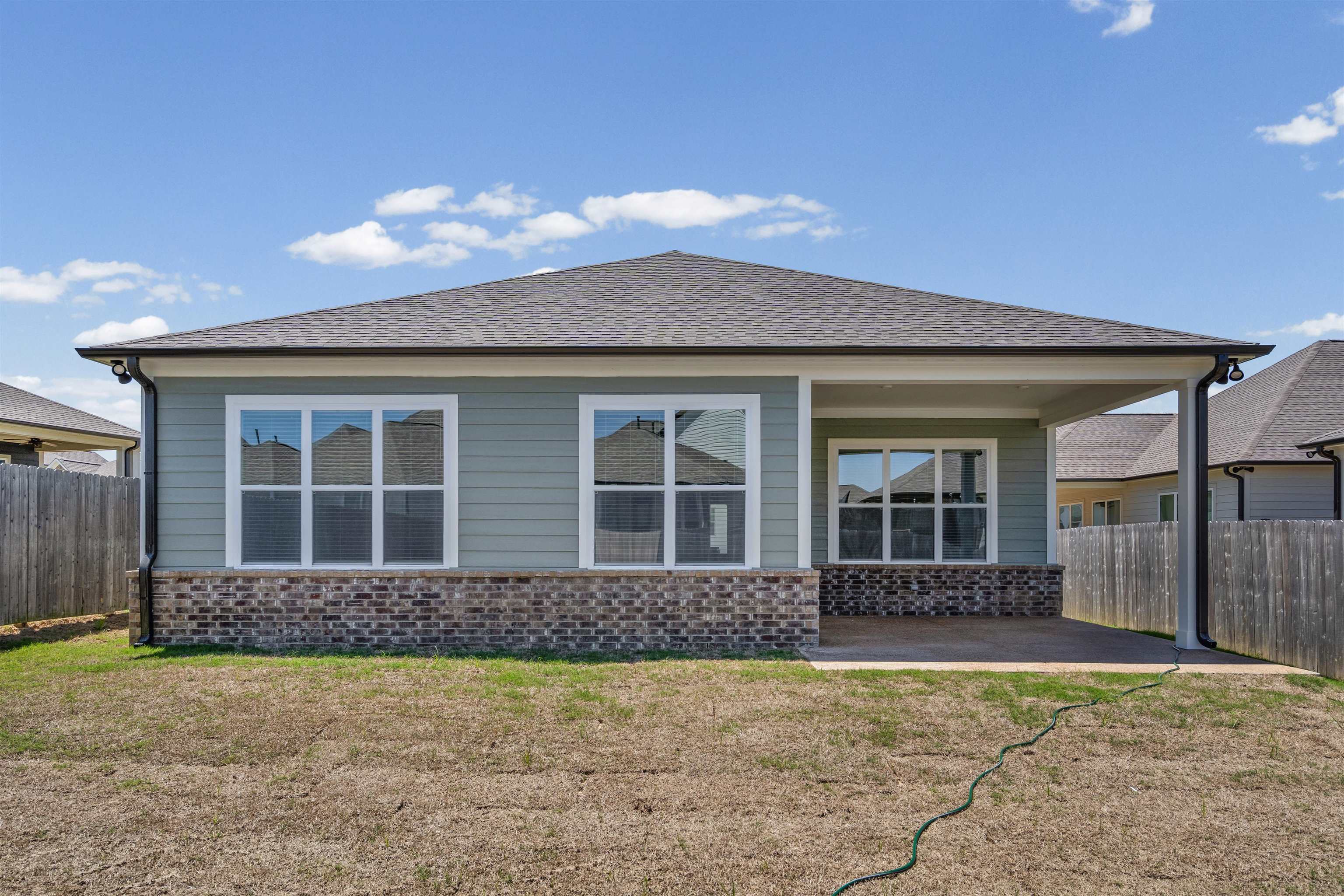 5666 Pleasant Pk Place Arlington, TN 38002 - Photo 25 of 27 Rear exterior featuring light blue siding, a dark shingle roof, and brick veneer detailing
