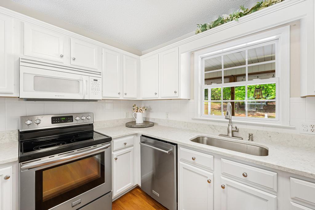 848 Perkins Creek Road Seneca, SC 29678 - Photo 10 of 26 This bright kitchen features white cabinetry and stainless steel appliances, creating a welcoming and functional space.