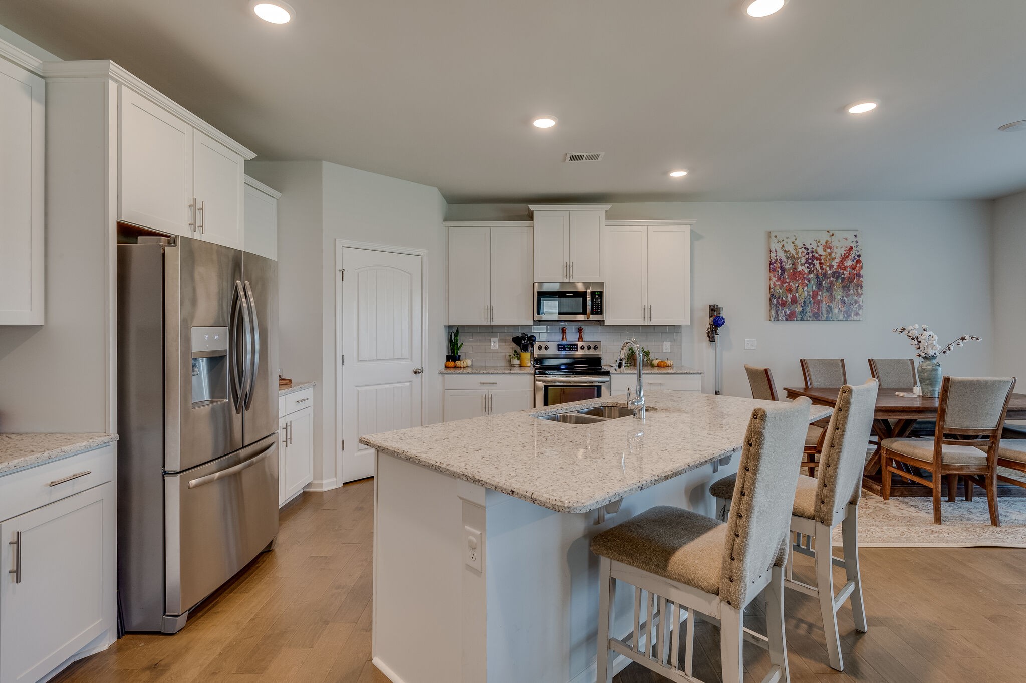 9003 Lockeland Drive Spring Hill, TN 37174 - Photo 6 of 16 a kitchen with stainless steel appliances granite countertop a refrigerator a stove a sink a dining table and chairs