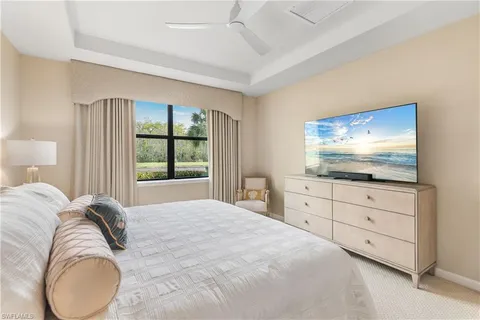 a bedroom with a large bed and a flat screen tv
