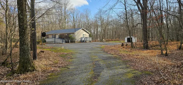 a view of a house with backyard and trees