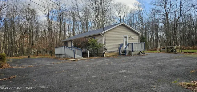 a view of a house with a yard and large tree