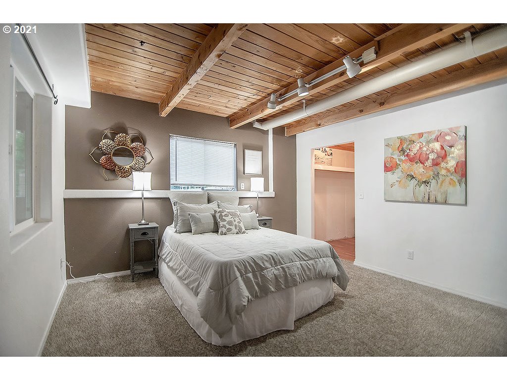 265 Curtis Hill Road Chehalis, WA 98532 - Photo 20 of 32 a bedroom with a large bed and a chandelier