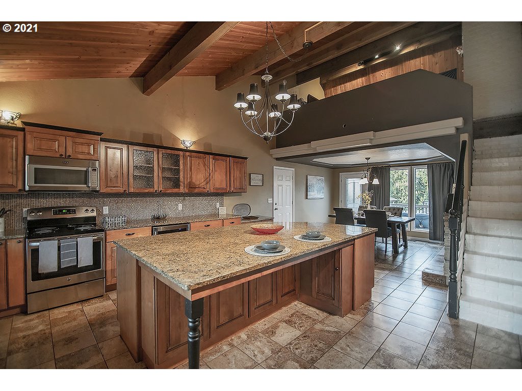265 Curtis Hill Road Chehalis, WA 98532 - Photo 6 of 32 a kitchen with a stove a kitchen island a dining table and chairs