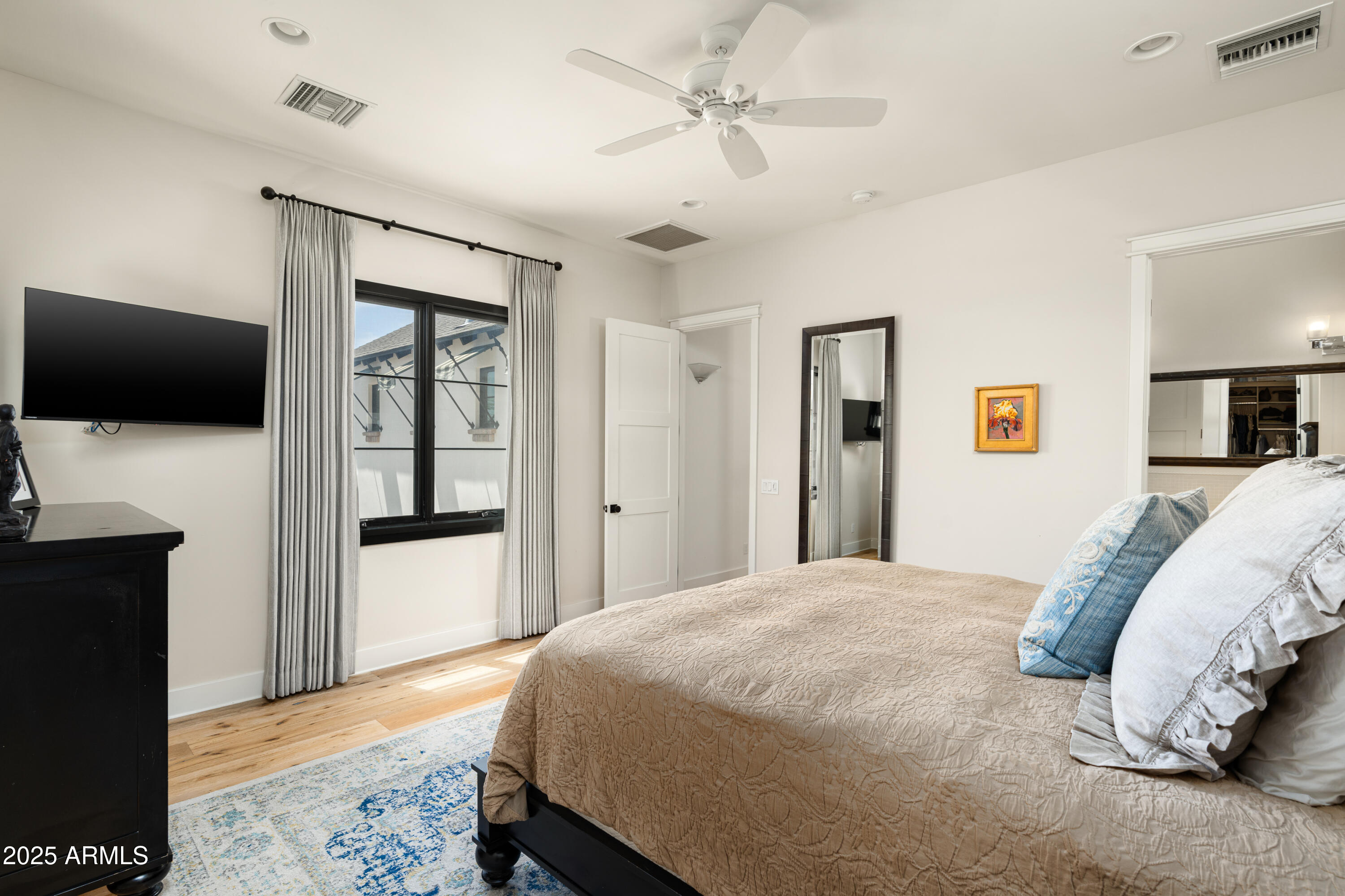 4901 East Amelia Avenue Phoenix, AZ 85018 - Photo 23 of 38 a spacious bedroom with a bed and a flat screen tv