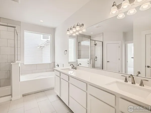 a spacious bathroom with a tub sink and mirror