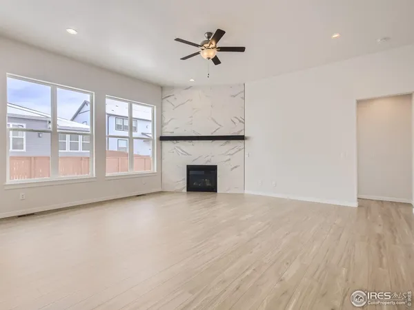 an empty room with windows and fireplace