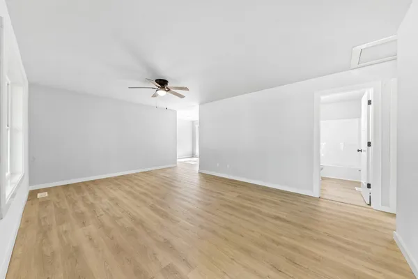 a view of a kitchen with refrigerator and wooden floor