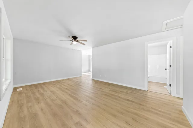 a view of a kitchen with refrigerator and wooden floor