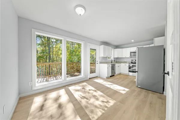 an empty room with windows and fan