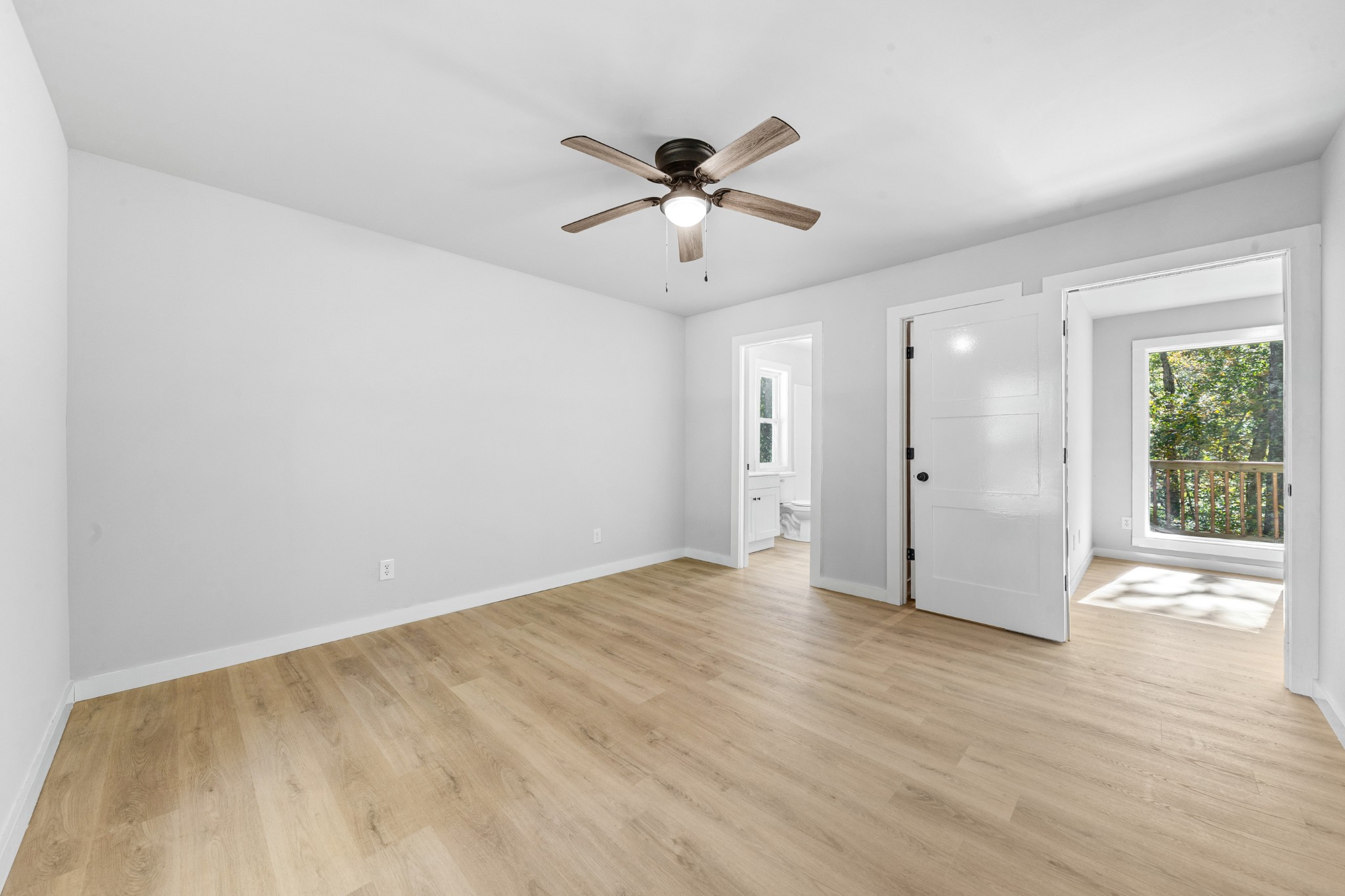 8240 Charlie Brown Road Centerville, TN 37033 - Photo 32 of 72 a view of an empty room with wooden floor and a ceiling fan