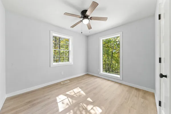a view of a house with a yard and large tree