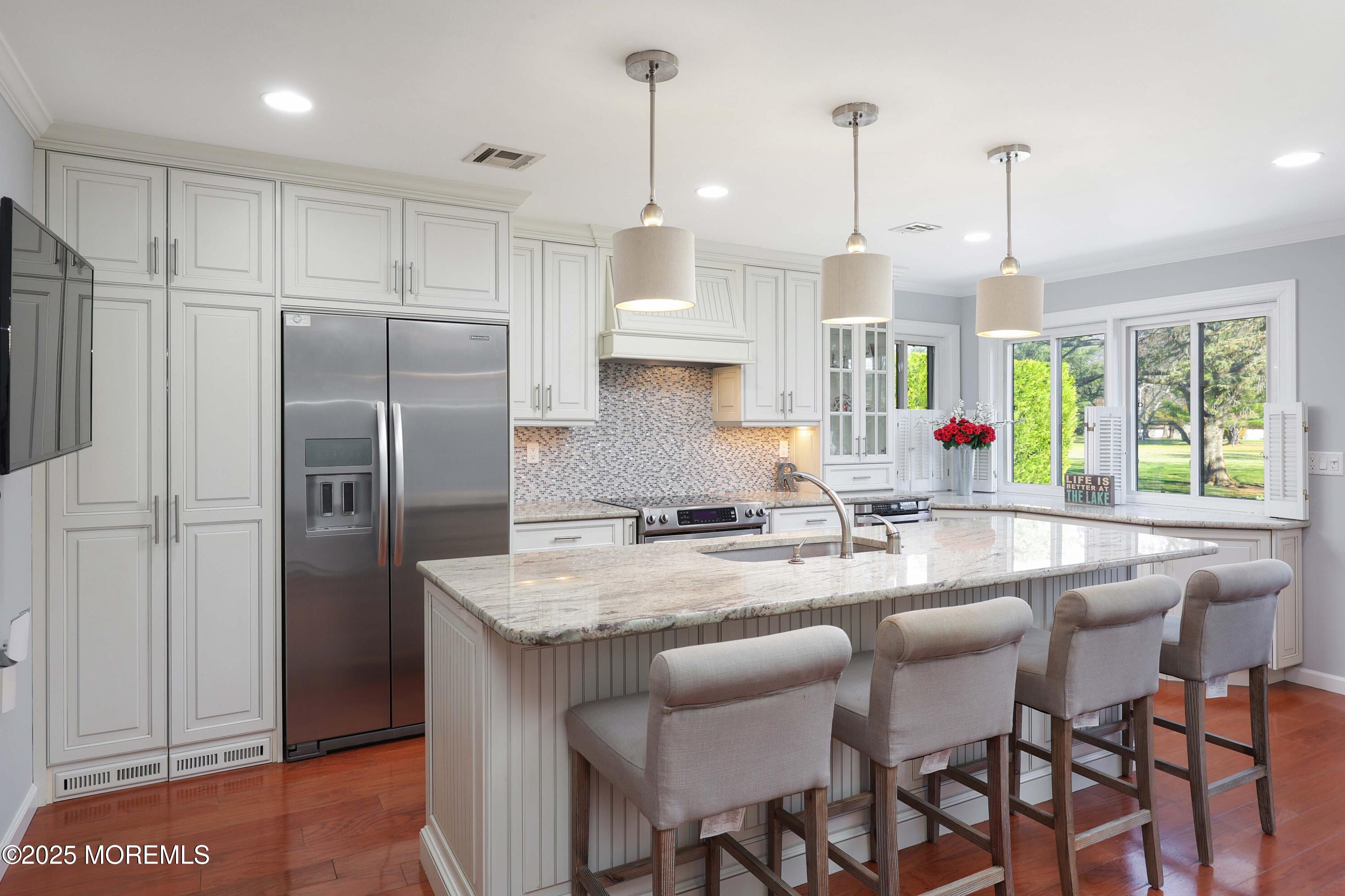 16 Concord Court Red Bank, NJ 07701 - Photo 8 of 63 a kitchen with granite countertop a center island a refrigerator a stove a dining table and chairs